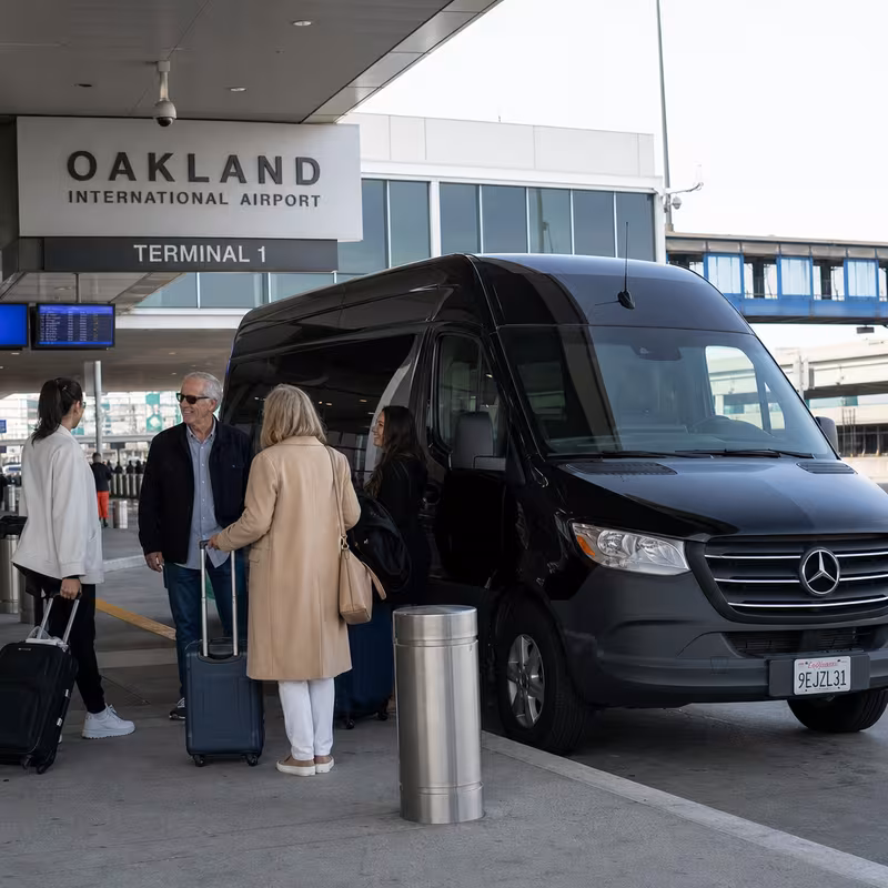 Group boarding a white charter bus for Airport Transportation transportation in Oakland
