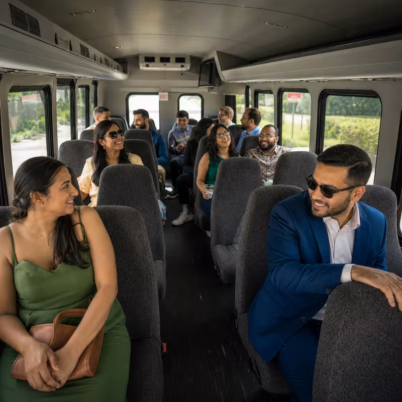 Group boarding a white charter bus for Private Event Transportation transportation in Oakland