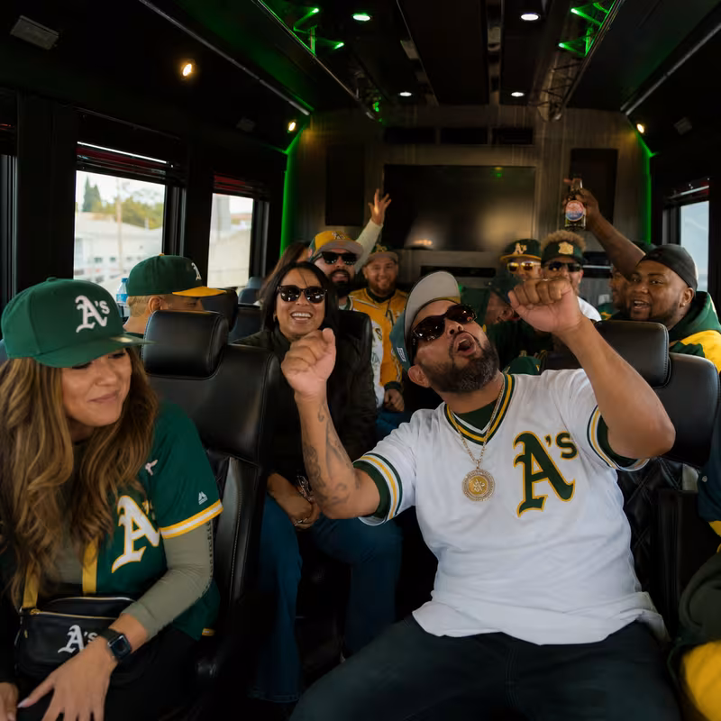 Group boarding a white charter bus for Sporting Event Transportation transportation in Oakland